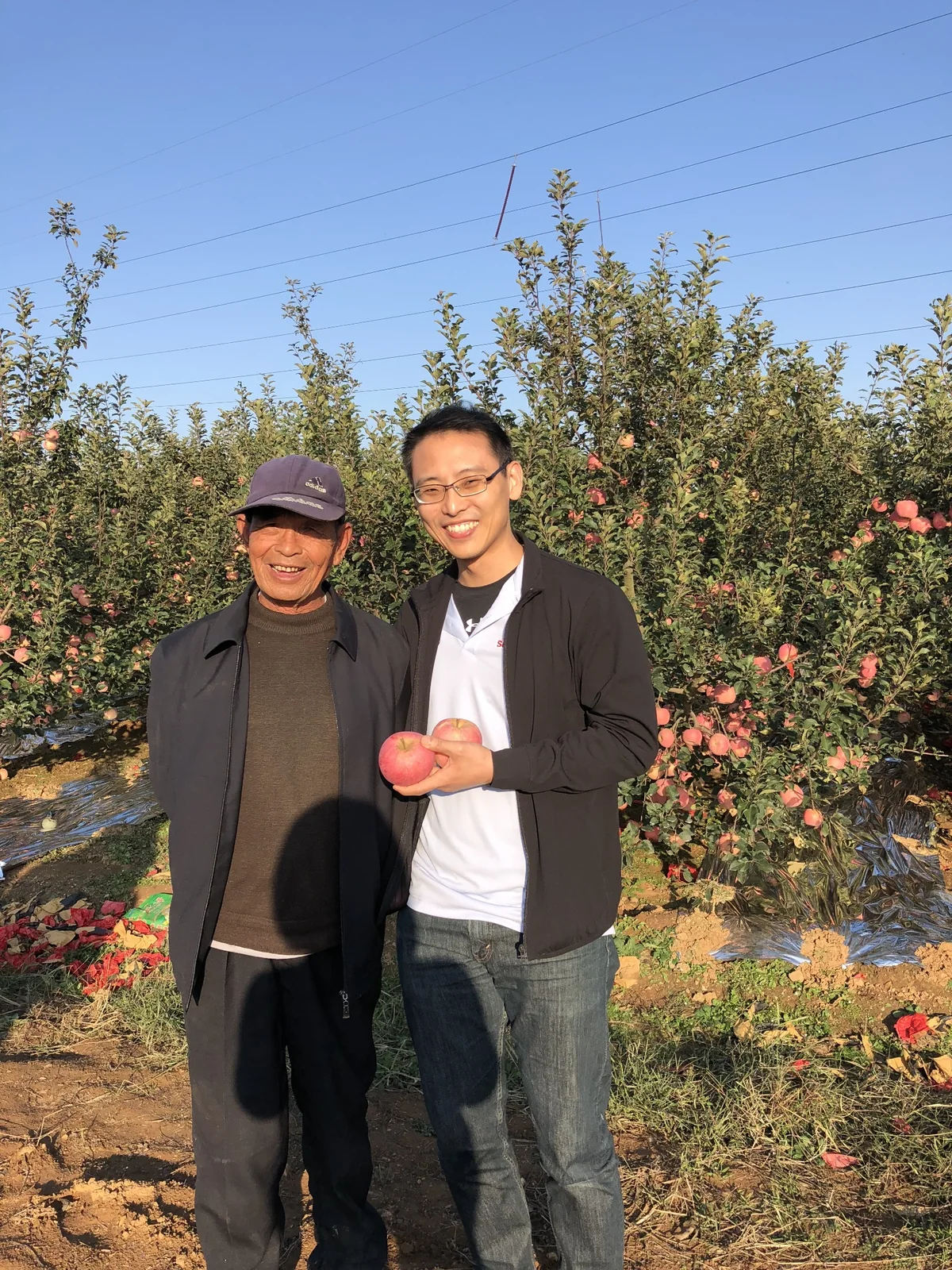 3YY Fresh representative photographed with an orchard grower during a sourcing visit